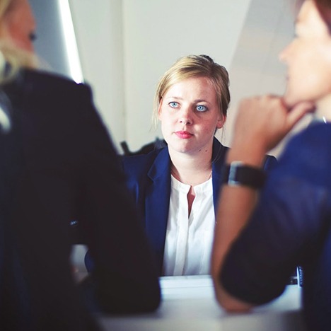 Image of two people interviewing/discussing with another person across the table