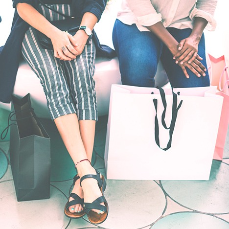 Two People sitting with bags and merchandise