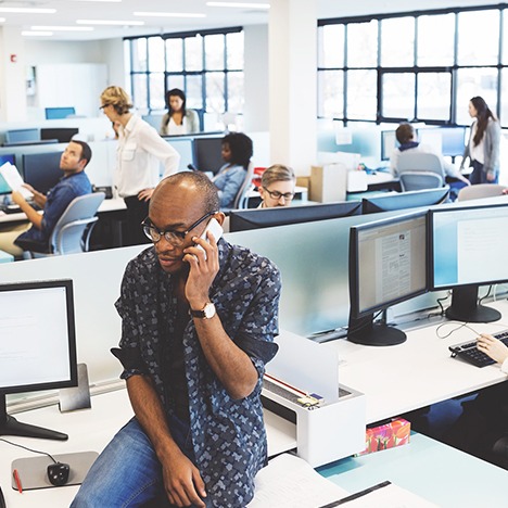 Large office full of people doing work and answering calls